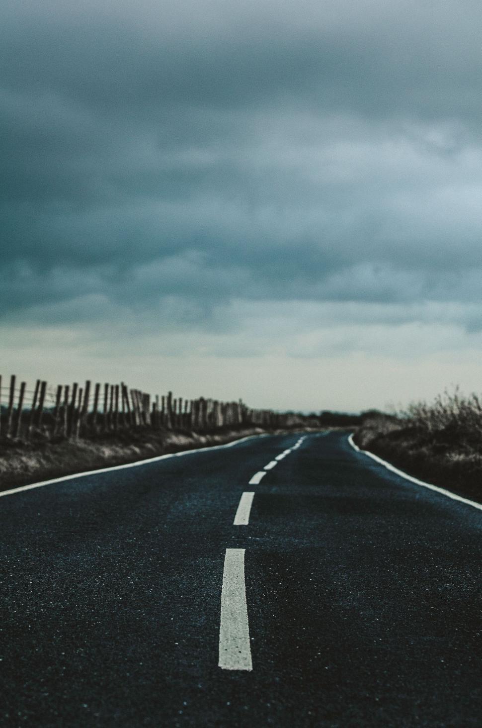 Free Image of Desolate country road under stormy skies 