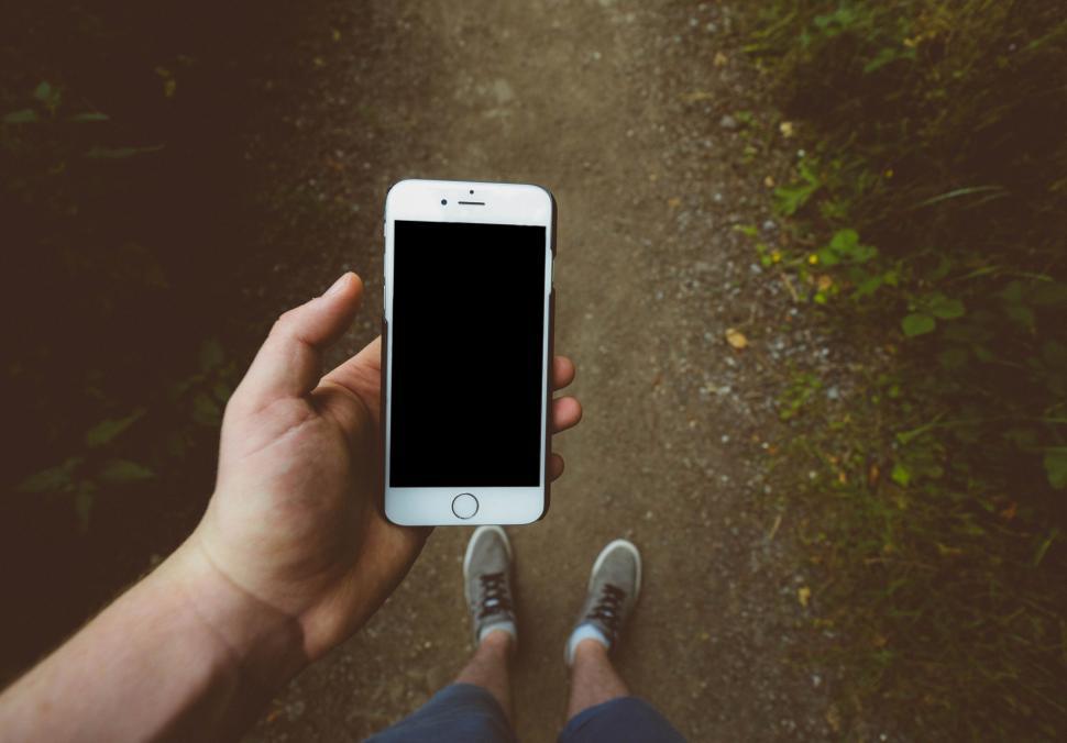 Free Image of Hand holding smartphone with blank screen outdoors 