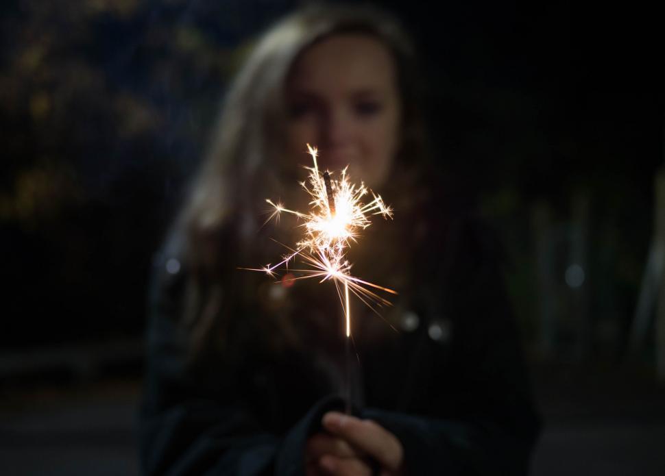 Free Image of Woman holding sparkler at night 