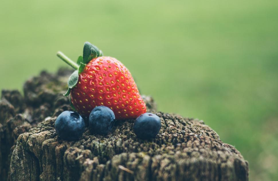Free Image of Juicy strawberry and blueberries on stump 