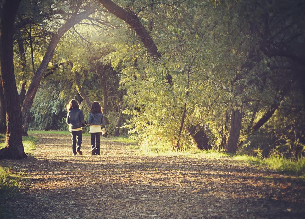 Free Image of Two People Walking Through an Autumn Park 