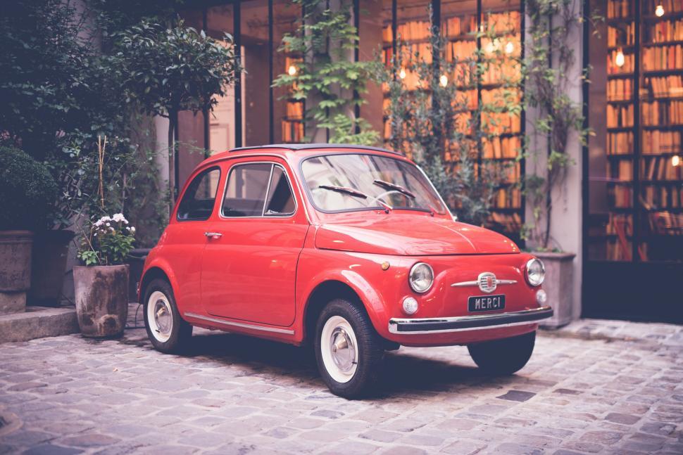 Free Image of Vintage red car parked in courtyard 