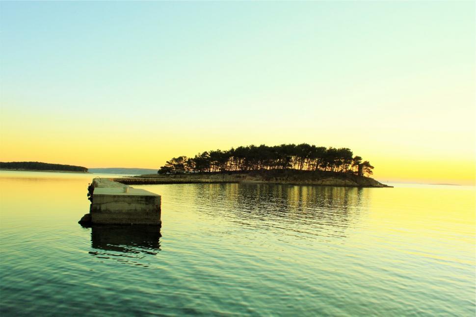 Free Image of Island at sunset in calm water 