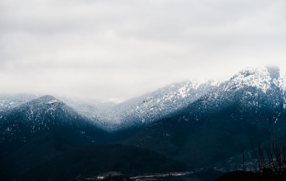 Free Image of Snow-capped mountains under cloudy sky 