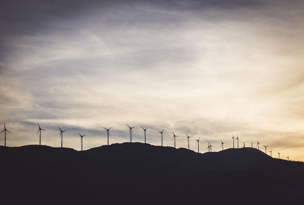Free Image of Silhouetted wind turbines on a hill at dusk 