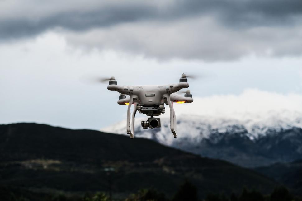 Free Image of Hovering drone against mountain backdrop 