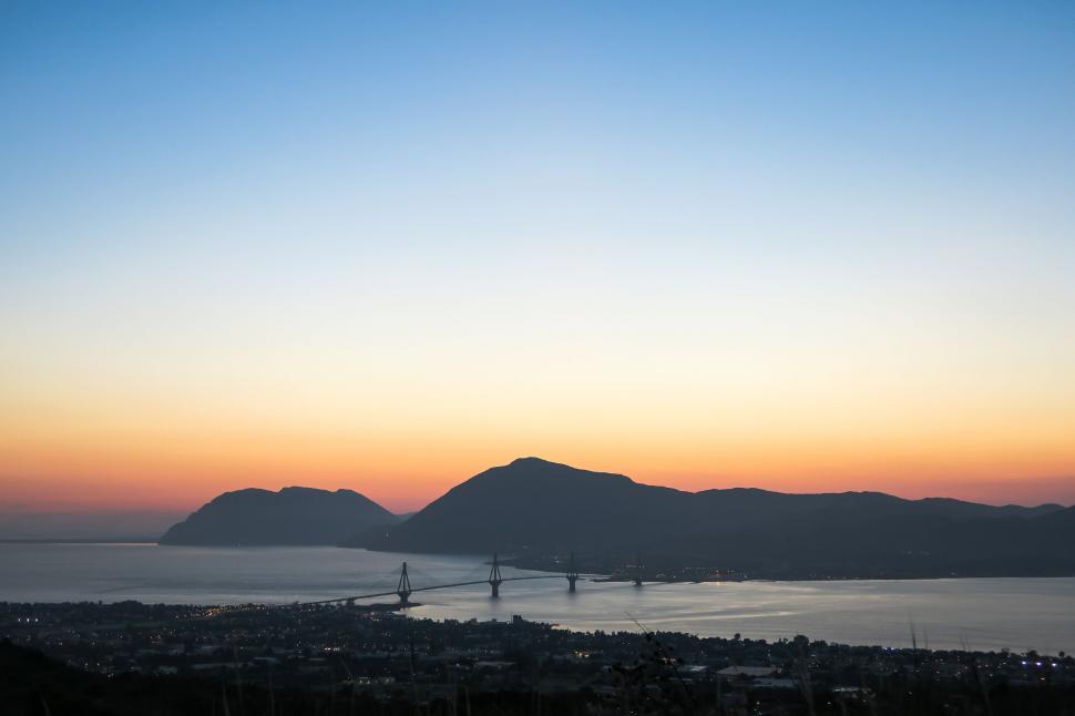Free Image of Sunset over a mountainous coastal landscape 