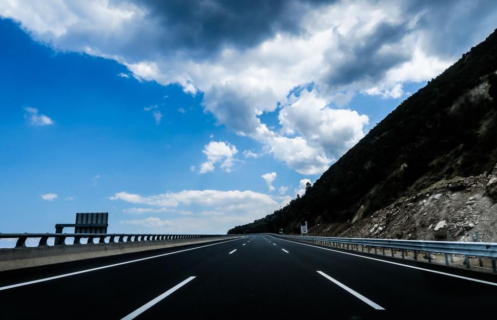 Free Image of Empty highway with blue sky and clouds 