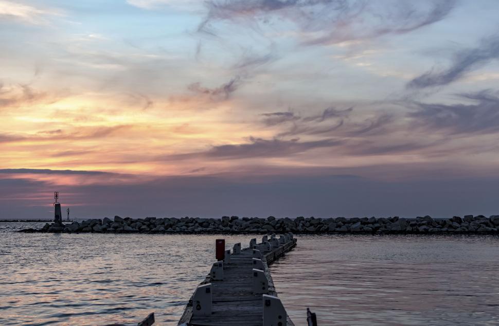 Free Image of Pier extending into sunset ocean scene 