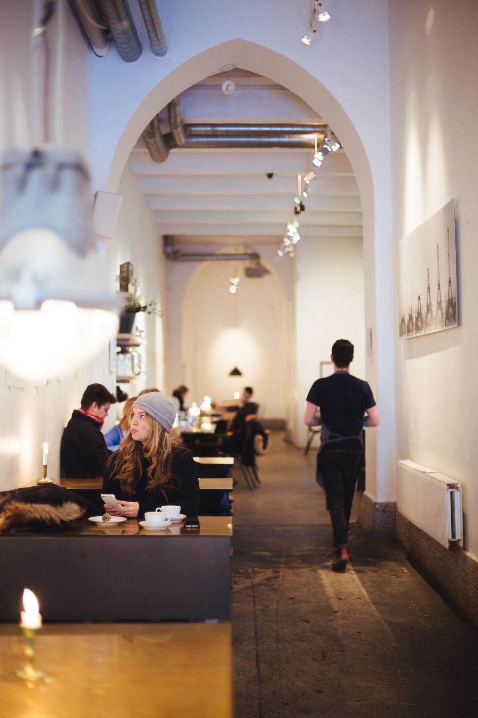 Free Image of Cafe interior with customers and warm lighting 