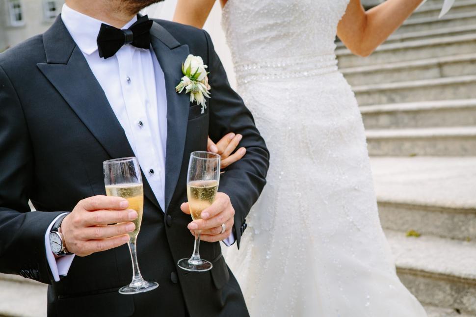 Free Image of Bride and groom clinking champagne glasses 