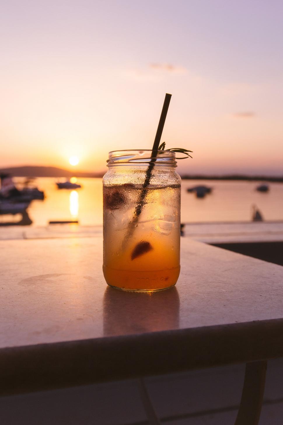 Free Image of Iced drink with sunset and boats backdrop 