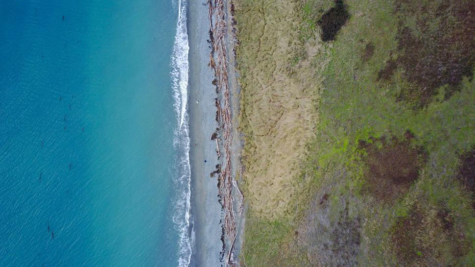 Free Image of Aerial photo of coast with waves and grass 