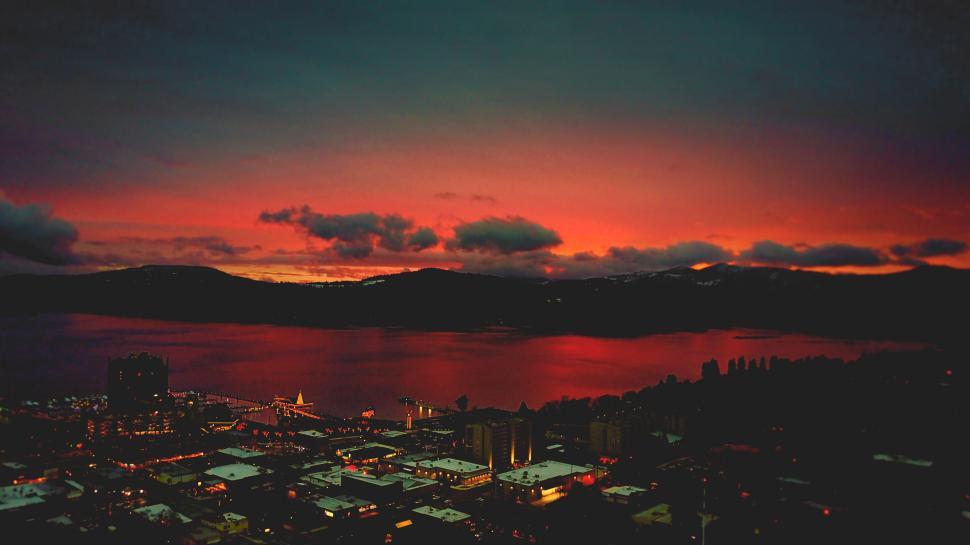 Free Image of Fiery sunset over a coastal cityscape 