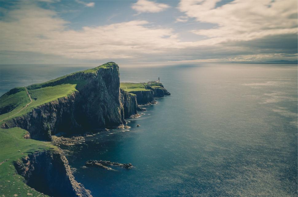 Free Image of Cliffside lighthouse over ocean vista 