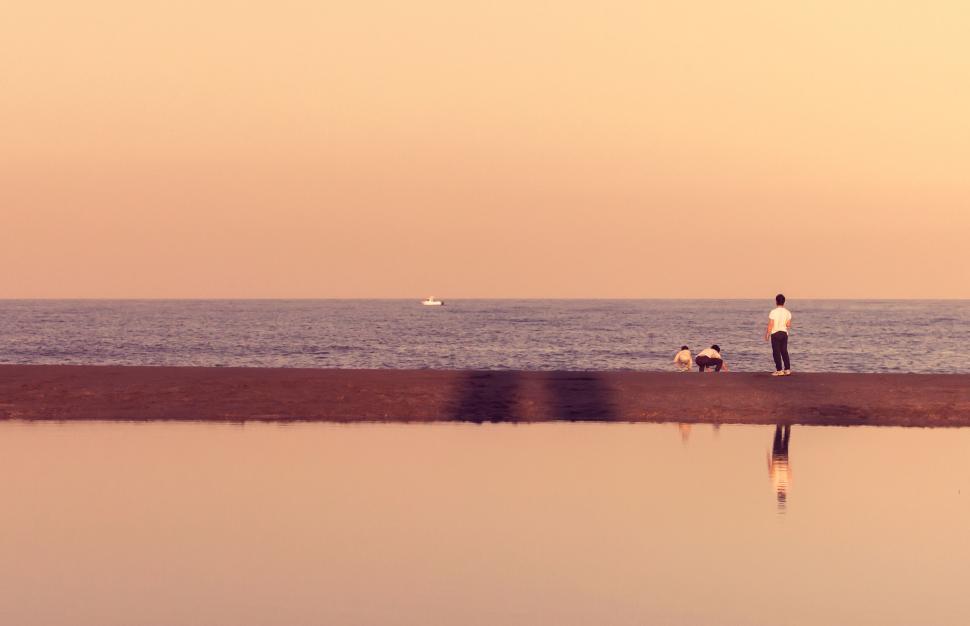 Free Image of Person and dog by serene sea at sunset 