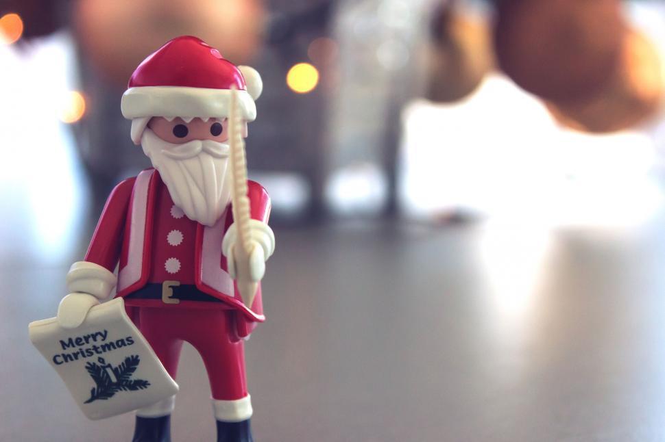Free Image of Santa figurine holding a Christmas sign 