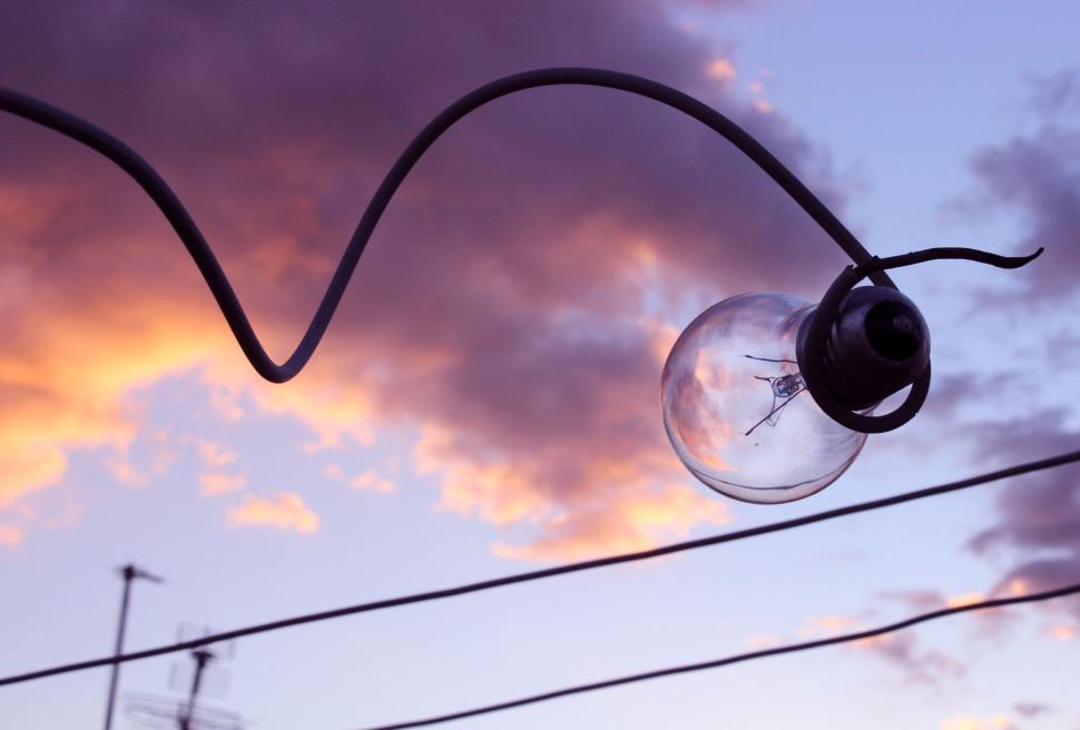 Free Image of Outdoor lightbulb against a sunset sky 