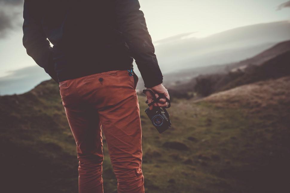 Free Image of Man holding camera in a rural landscape 