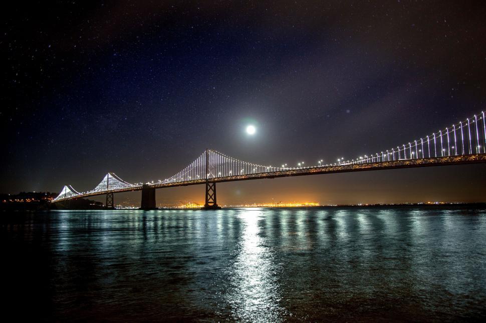 Free Image of Moonlit bridge over water at night 