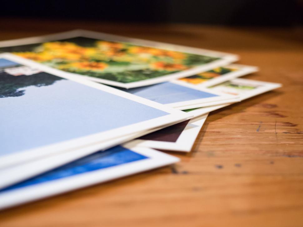 Free Image of Stack of travel postcards on table 