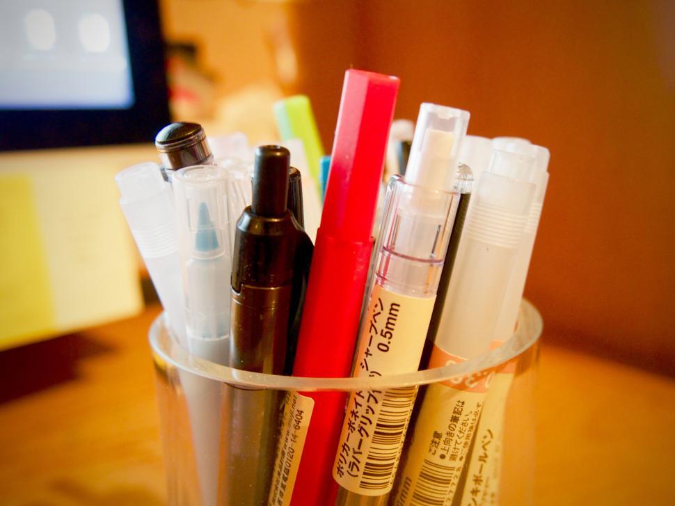 Free Image of Assorted markers in a clear plastic cup 