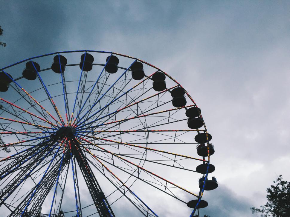 Free Image of Ferris wheel silhouette against cloudy sky 