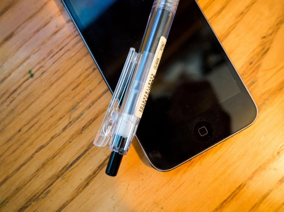 Free Image of Smartphone and stylus pen on wooden surface 