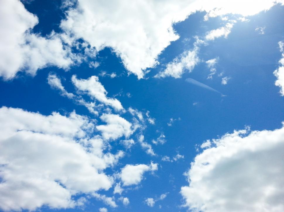 Free Image of Fluffy clouds in a vibrant blue sky 