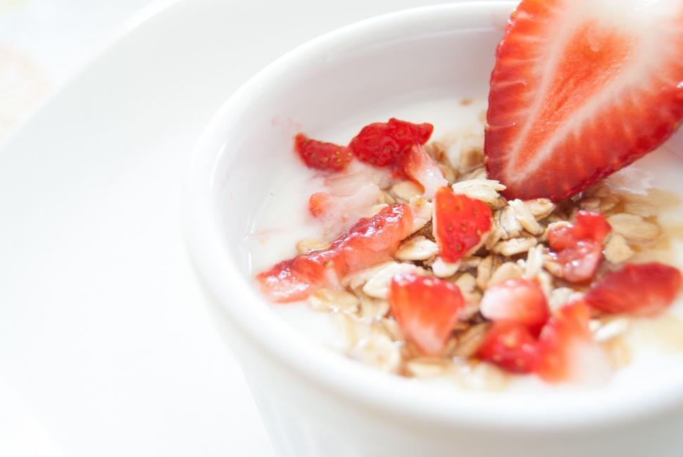 Free Image of Close-up of a yogurt cup with strawberries and granola 
