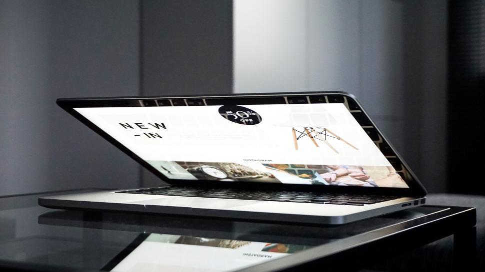 Free Image of Laptop on desk displaying modern website 