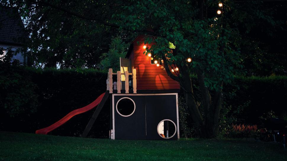 Free Image of Playhouse with slide in evening backyard 