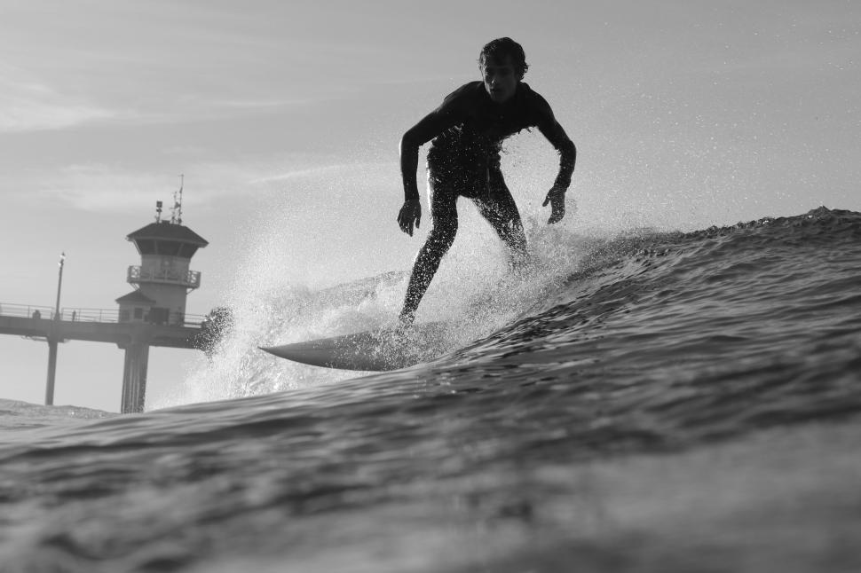 Free Image of Surfer riding a wave in black and white 