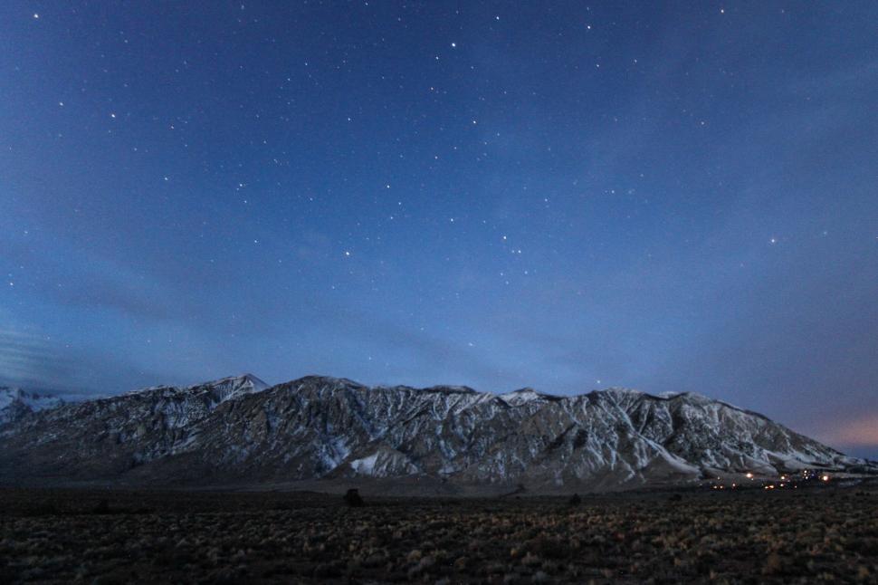 Free Image of Starry night over snow-capped mountains 