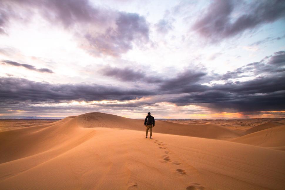 Free Image of Person walking on sandy desert dunes 