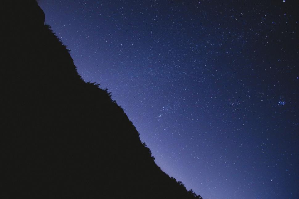 Free Image of Starry night sky over silhouette mountain 