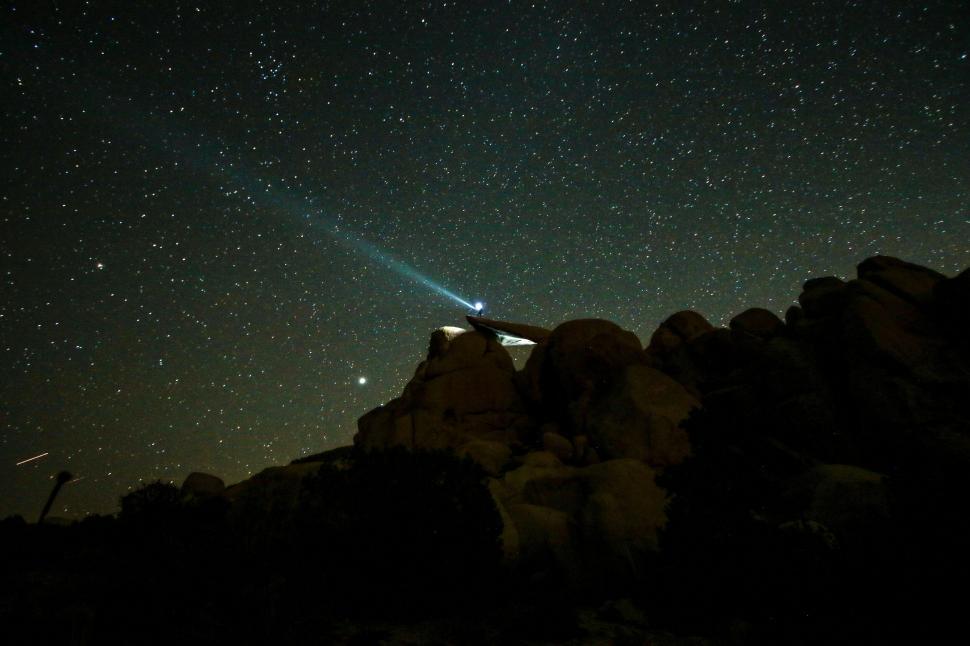 Free Image of Stars and comet over illuminated rock formations 