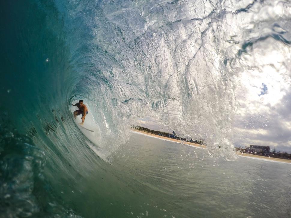 Free Image of Surfer riding a wave inside a barrel 