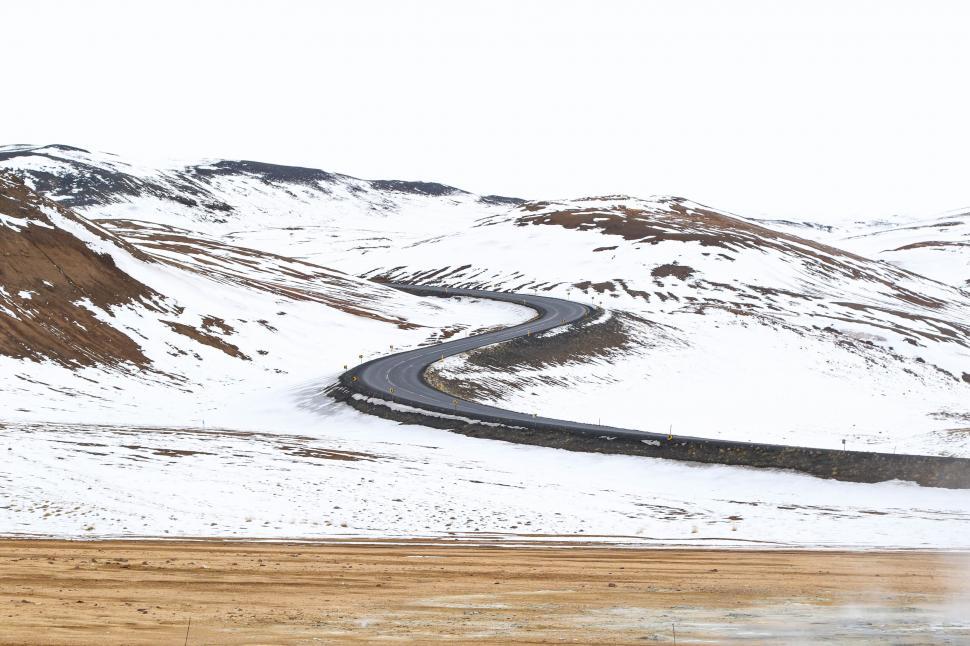 Free Image of Curvy road through snowy mountain landscape 