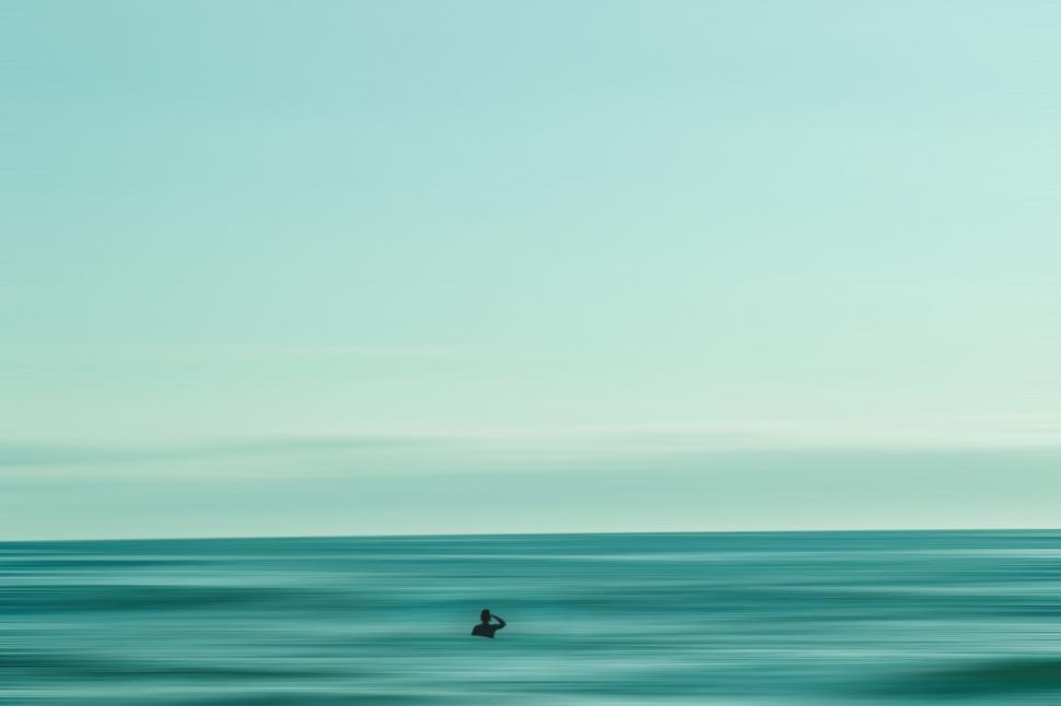 Free Image of Minimalist shot of person in vast ocean 