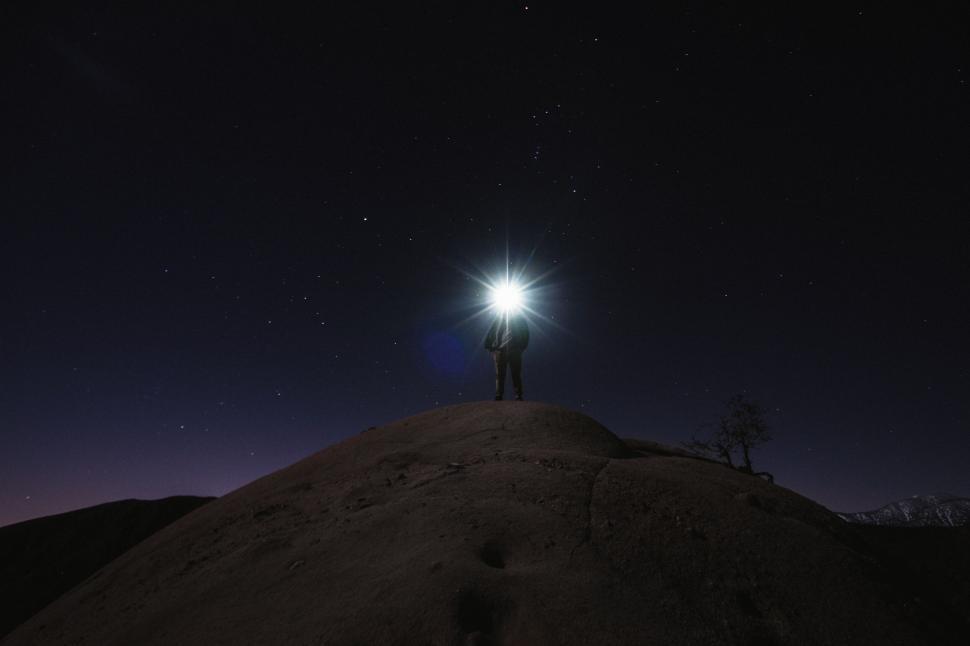 Free Image of Person standing under starry sky with bright light 
