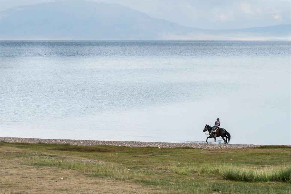 Free Image of Horseback rider by a tranquil mountain lake 