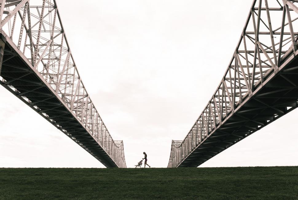 Free Image of Person walking under a steel bridge 