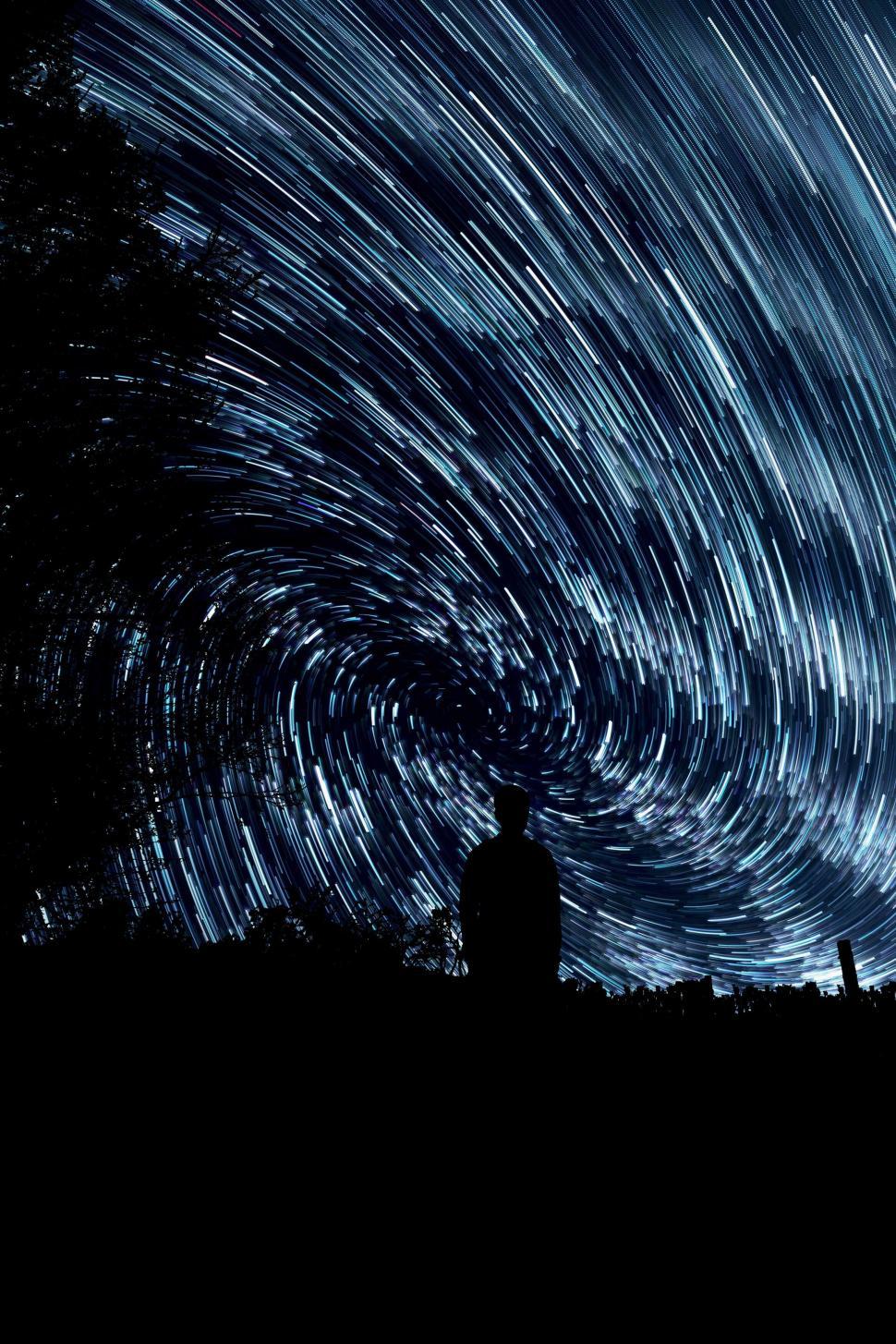 Free Image of Star trails with silhouette of a standing person 