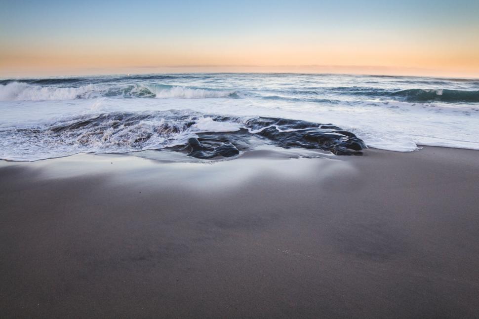 Free Image of Seashore with waves and sand at sunset 