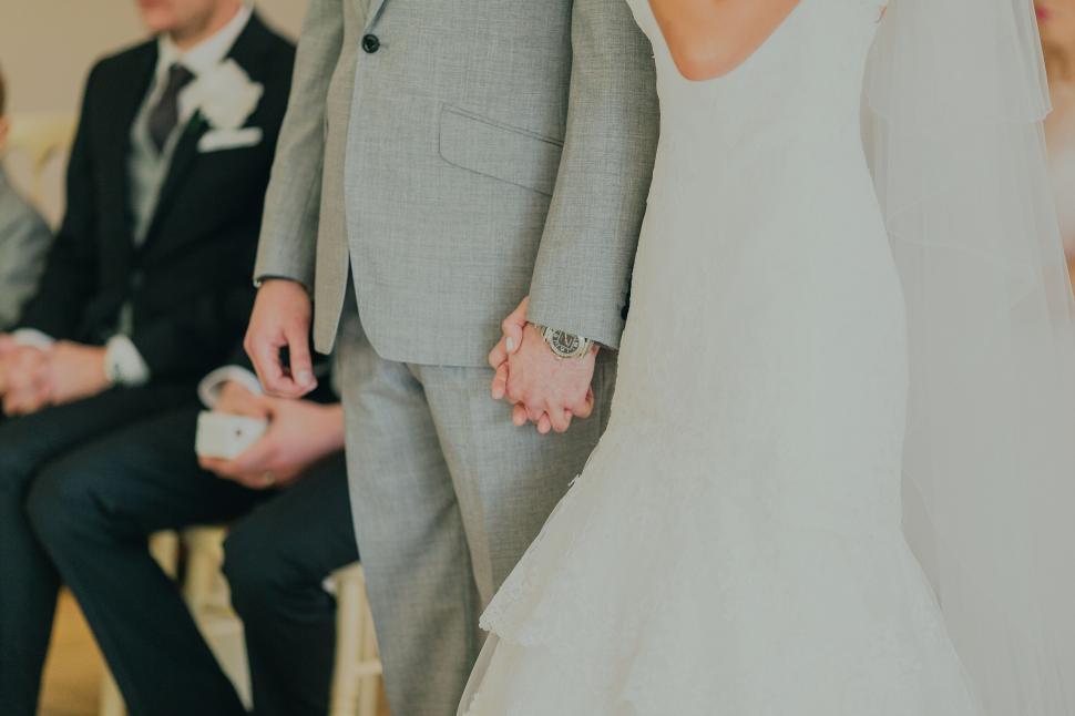 Free Image of Bride and groom holding hands at wedding 