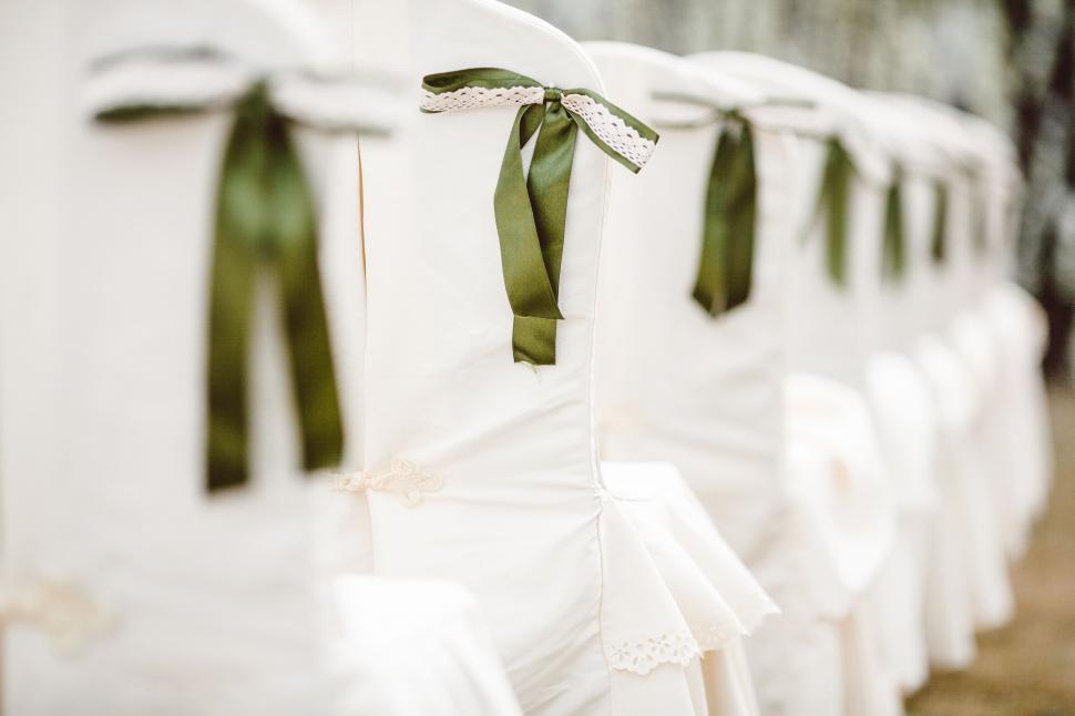 Free Image of Chairs with green ribbons at wedding event 