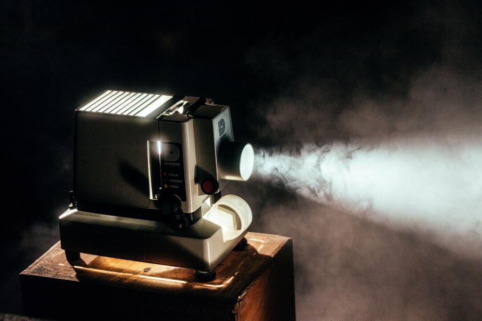 Free Image of Vintage projector casting light in dark room 