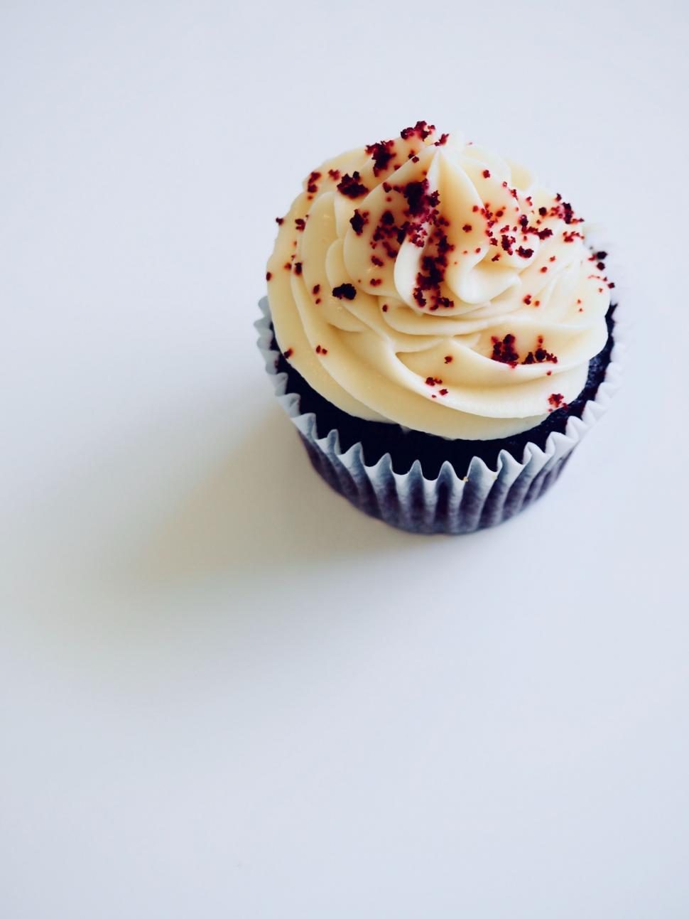 Free Image of Single cupcake with white frosting on plain background 
