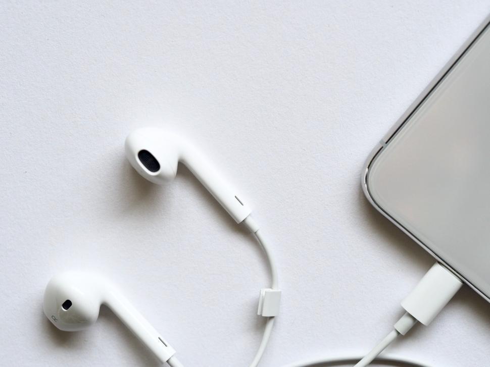 Free Image of Smartphone and earbuds on white background 